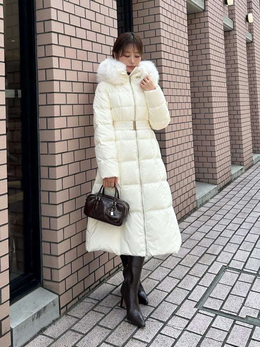 ブラック系のブーツ、ブラック系のボストンバッグ、ホワイト系のダウンジャケット/コートを着用したレディースの秋コーディネートの6枚目の写真