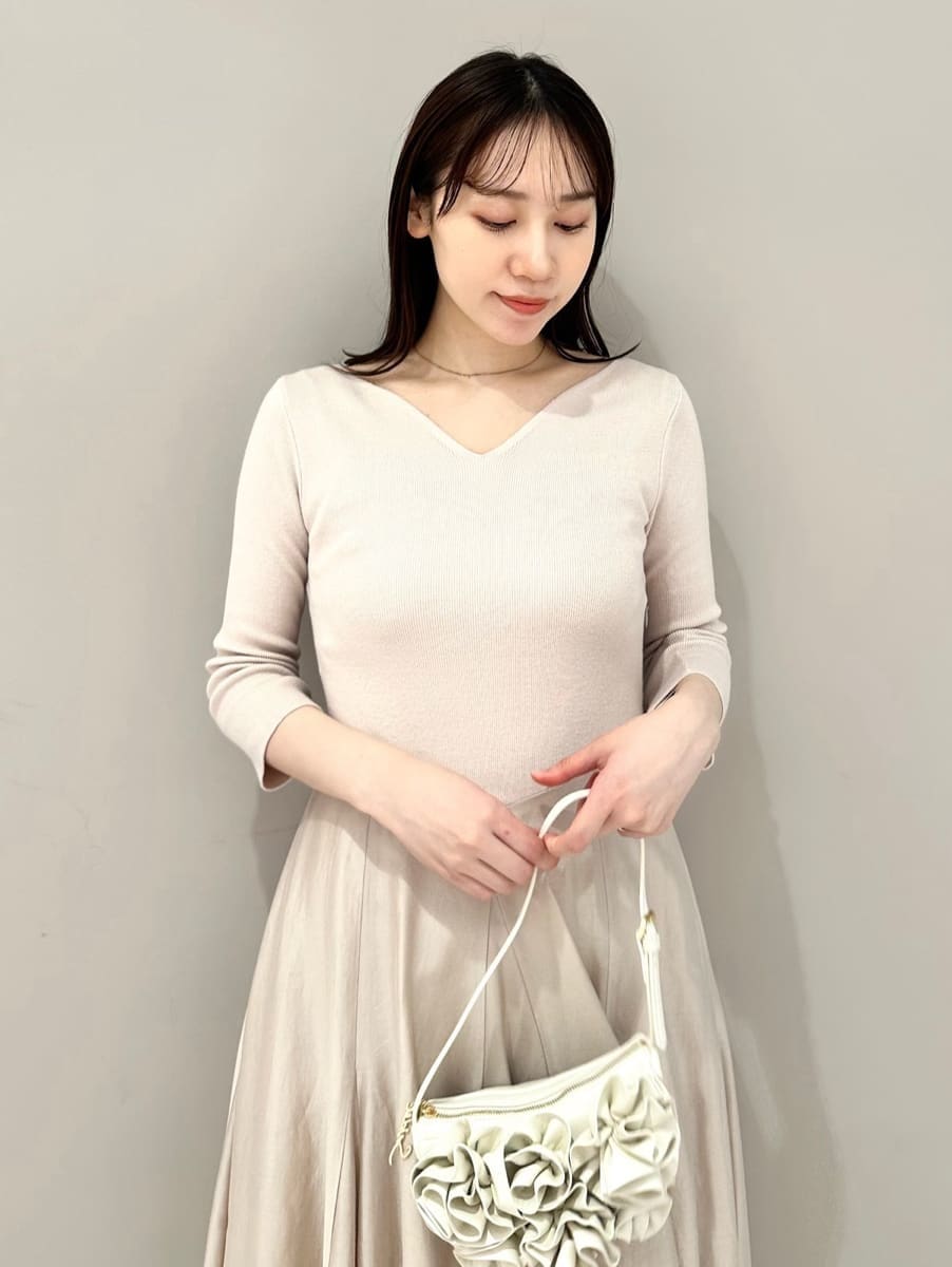 ブラウン系のパンプス、ホワイト系のハンドバッグを着用したレディースの冬コーディネートの2枚目の写真