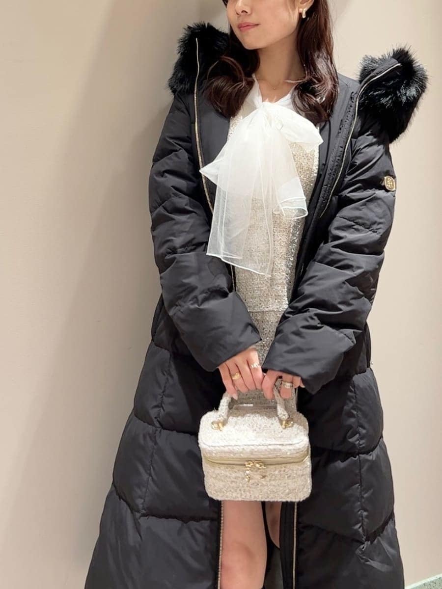 ホワイト系のニット/セーター、ブラック系のブーツ、ブラック系のダウンジャケット/コートを着用したレディースの冬コーディネートの4枚目の写真