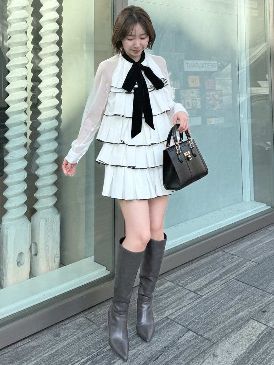 ホワイト系のドレス、ブラック系のハンドバッグを着用したレディースの冬コーディネートの8枚目の写真