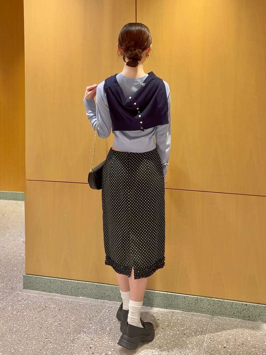 ブラック系のスカート、ブルー系のカーディガン/ボレロ、ブラック系のショルダーバッグを着用したレディースの冬コーディネートの3枚目の写真