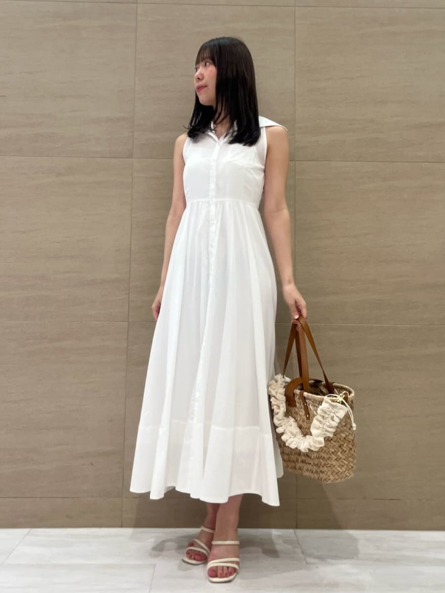 ホワイト系のワンピース、ブラウン系のかごバッグ、ホワイト系のパンプスを着用したレディースの夏コーディネートの2枚目の写真