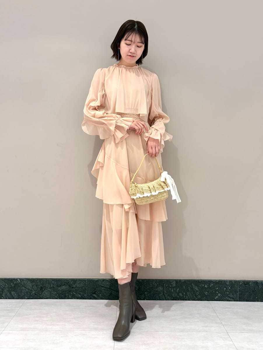 ピンク系のワンピース、ピンク系のカーディガン/ボレロ、ゴールド系のイヤリングを着用したレディースの冬コーディネートの2枚目の写真