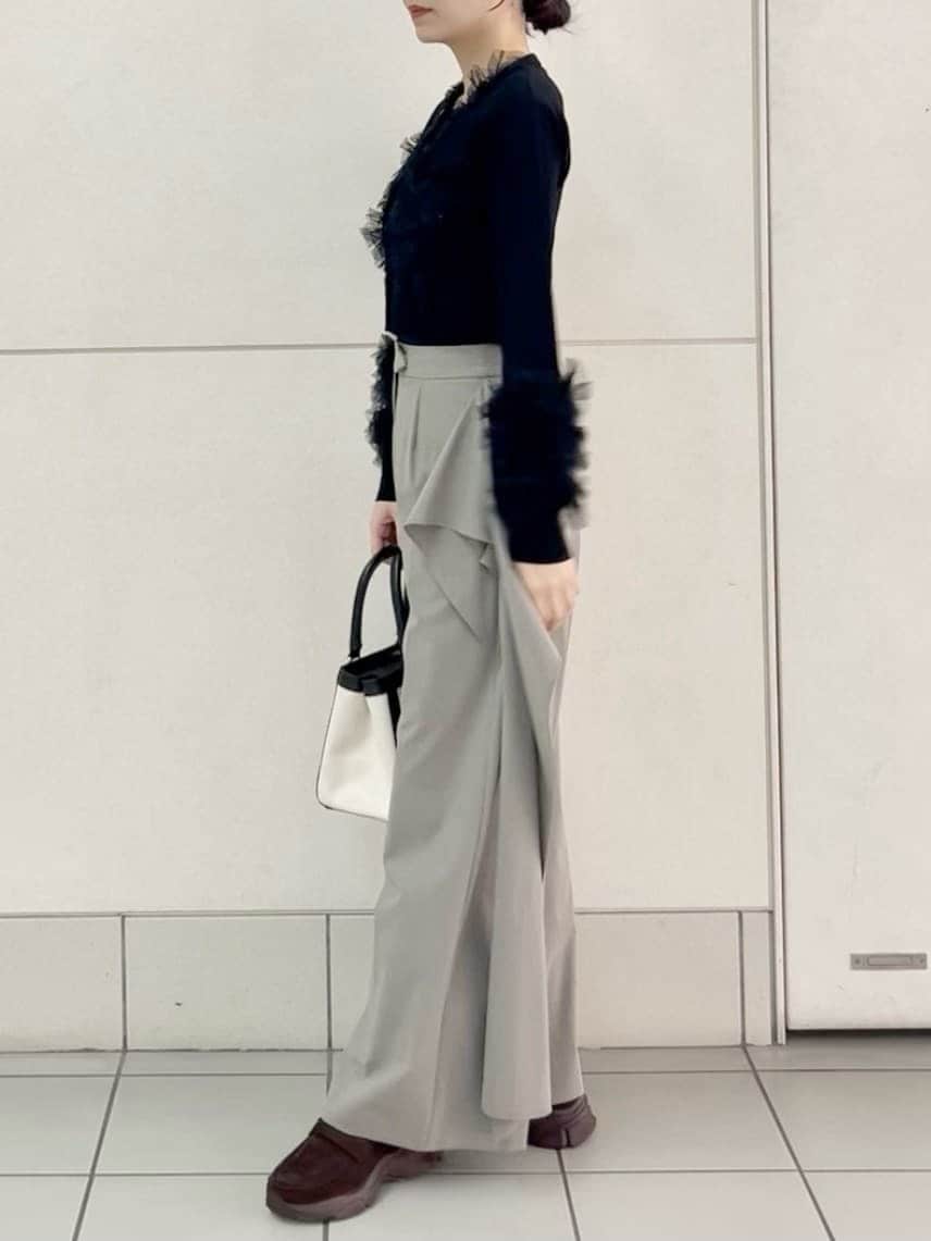 ベージュ系のその他パンツ、ブラック系のカーディガン/ボレロ、ホワイト系のハンドバッグを着用したレディースの春コーディネートの3枚目の写真