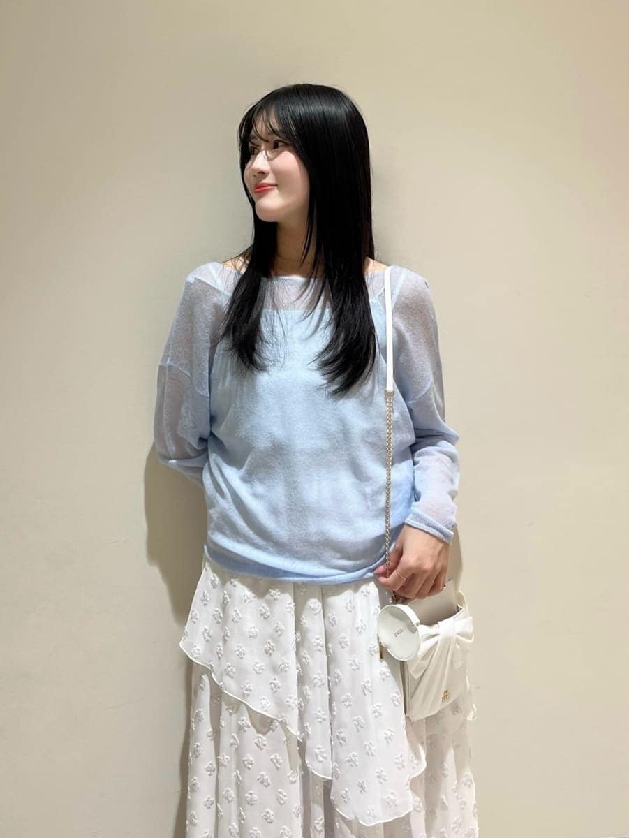 シルバー系のスカート、ブルー系のニット/セーター、ホワイト系のショルダーバッグを着用したレディースの冬コーディネートの3枚目の写真