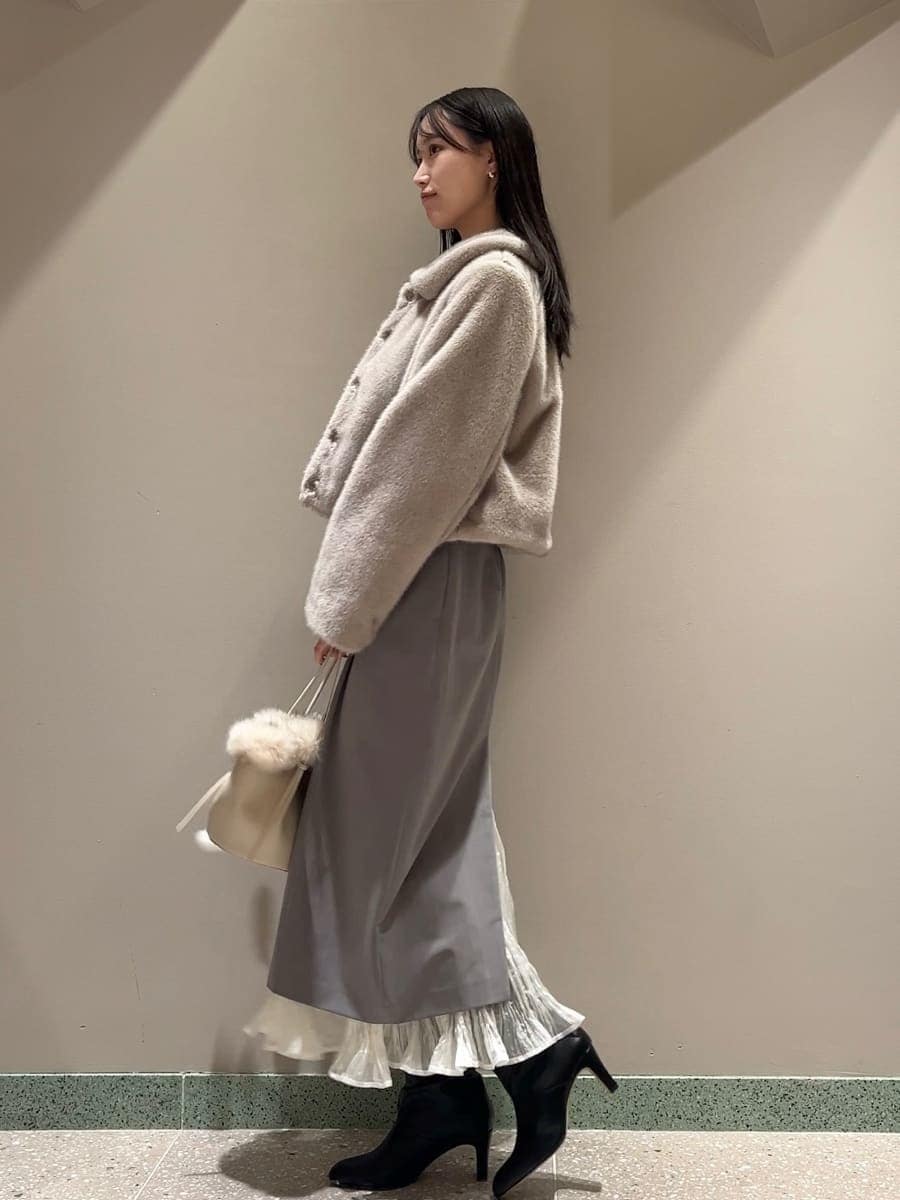 ベージュ系のステンカラーコート、その他のスカート、ホワイト系のハンドバッグを着用したレディースの秋コーディネートの4枚目の写真