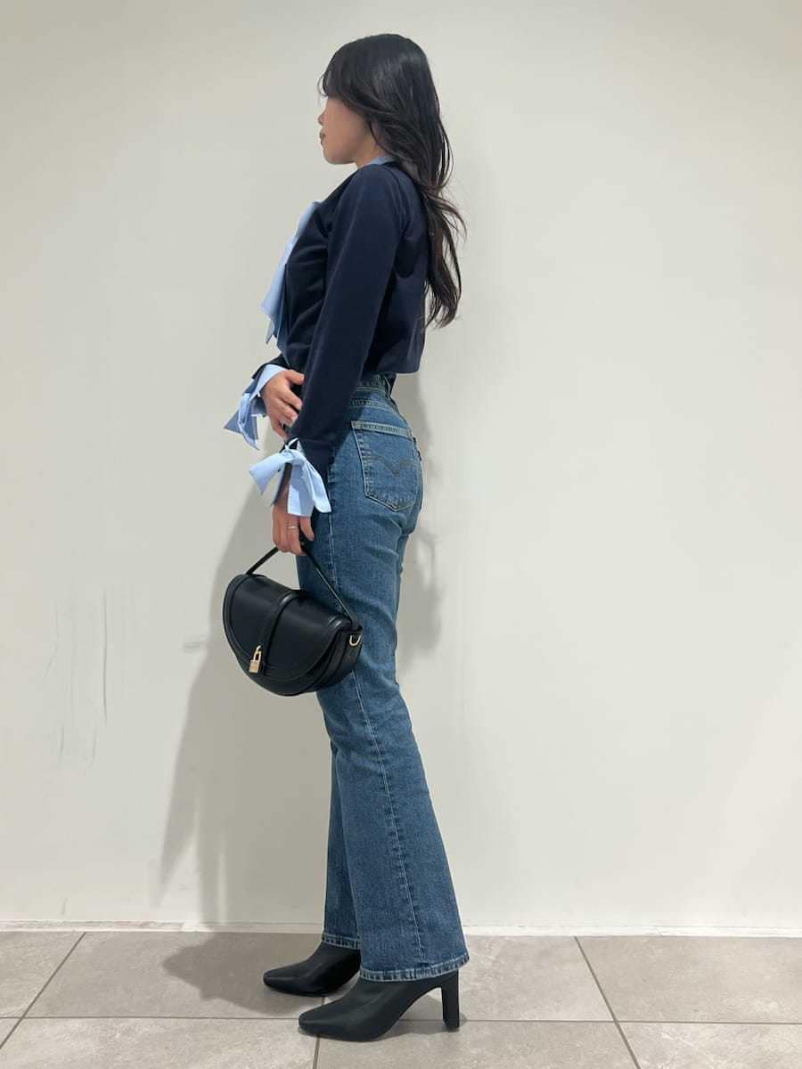 ブルー系のニット/セーター、ブルー系のデニムパンツ、ブラック系のブーツを着用したレディースの秋コーディネートの2枚目の写真