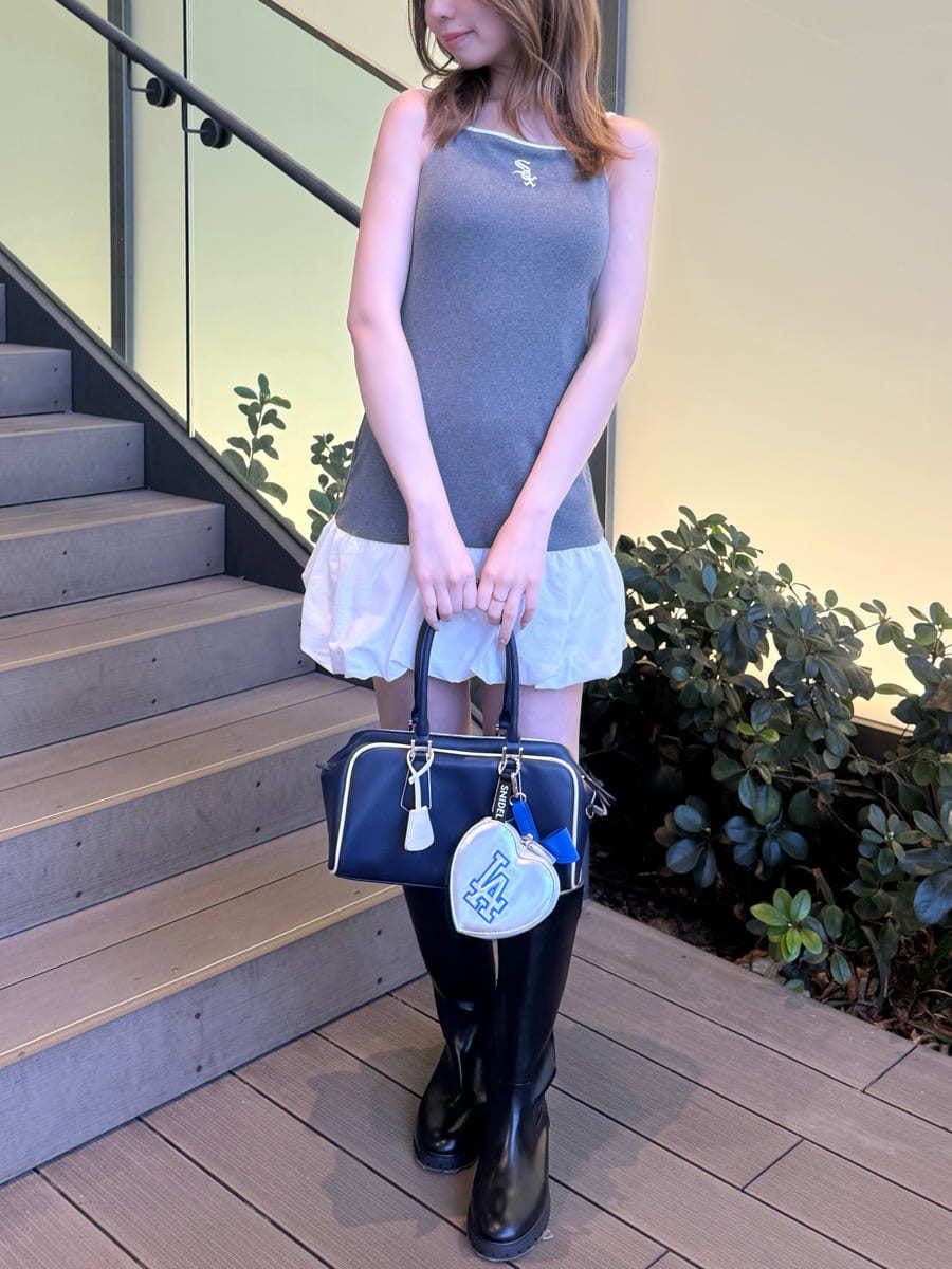 グレー系のワンピース、ブルー系のボストンバッグ、シルバー系のキーケース/キーアクセサリーを着用したレディースの春コーディネートの2枚目の写真