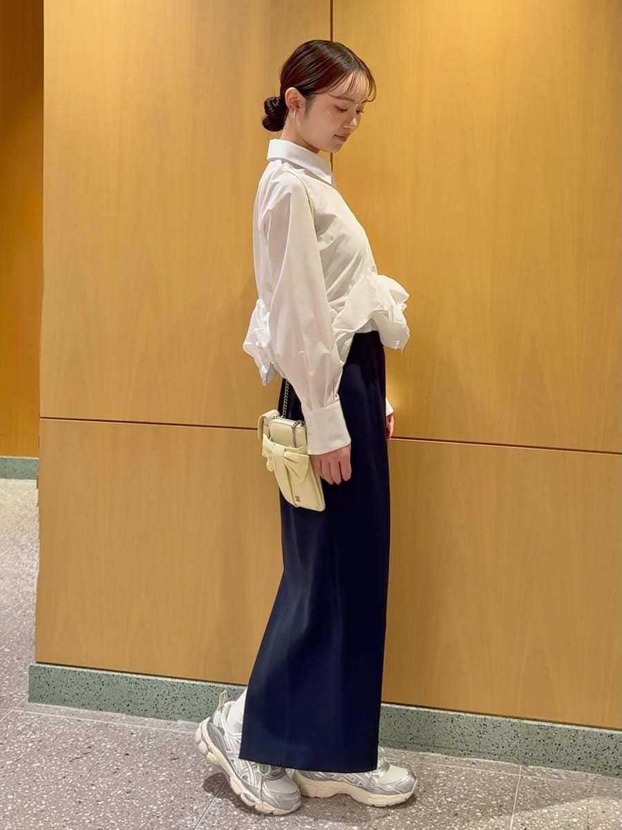 ブルー系のスカート、ホワイト系のシャツ/ブラウス、イエロー系のショルダーバッグを着用したレディースの冬コーディネートの3枚目の写真