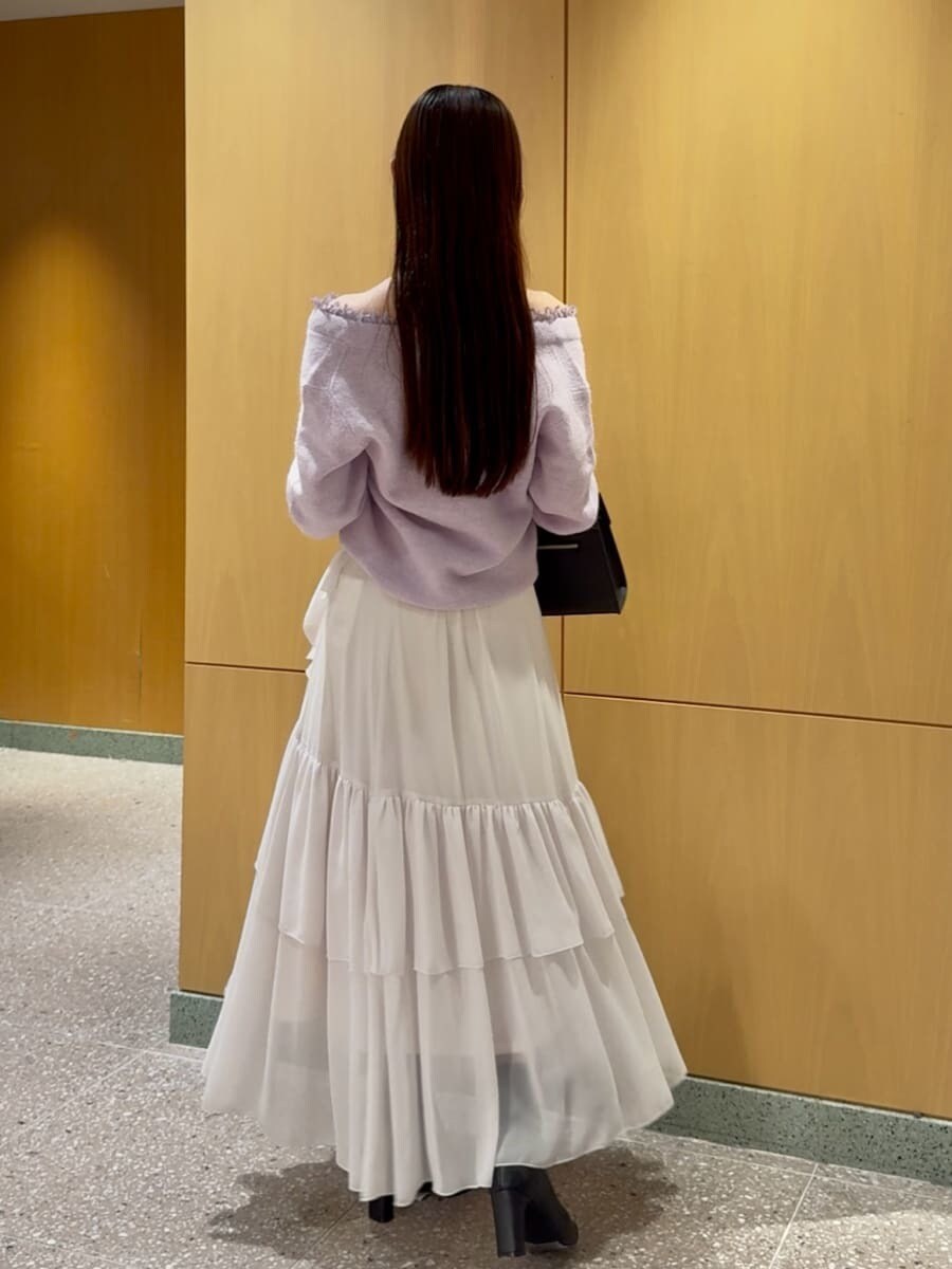 パープル系のニット/セーター、ホワイト系のスカート、ブラック系のブーツを着用したレディースの秋コーディネートの3枚目の写真