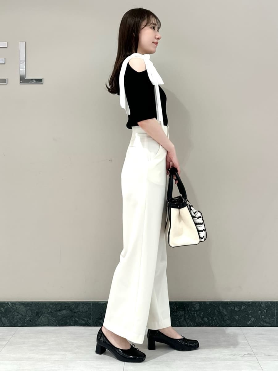 ホワイト系のスラックス、ホワイト系のハンドバッグ、ブラック系のパンプスを着用したレディースの春コーディネートの3枚目の写真