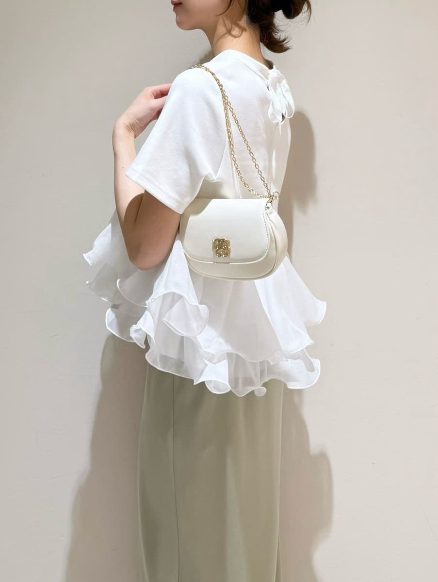 グリーン系のスカート、ホワイト系のTシャツ/カットソー、ホワイト系のショルダーバッグを着用したレディースの春コーディネートの4枚目の写真