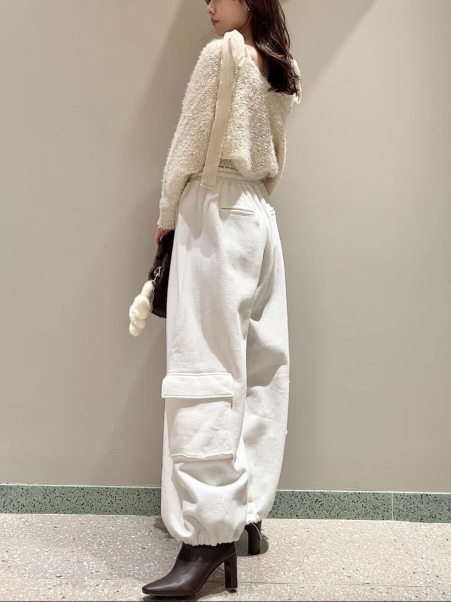 レッド系のブーツ、ホワイト系のニット/セーター、ホワイト系のスウェットパンツを着用したレディースの冬コーディネートの2枚目の写真