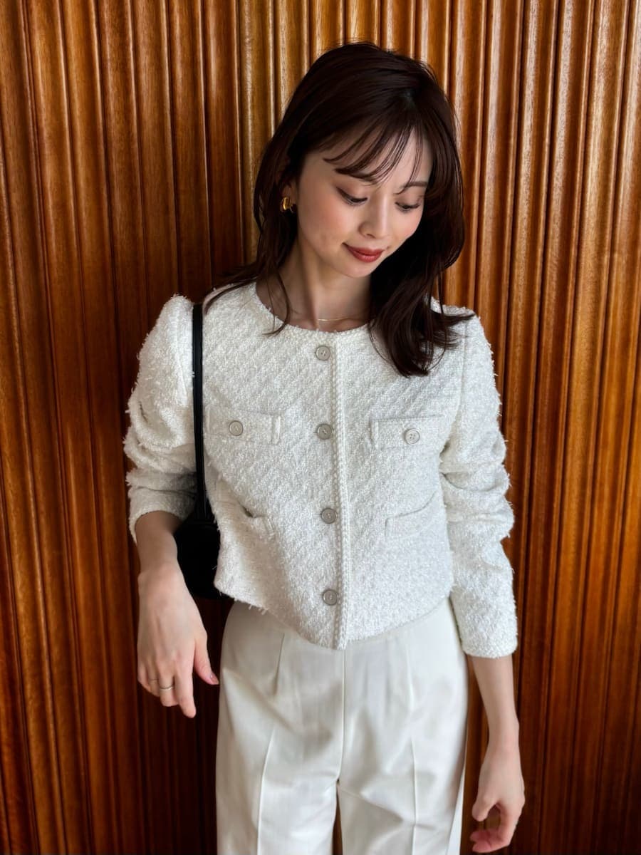 ホワイト系のスラックス、ホワイト系のノーカラージャケットを着用したレディースの冬コーディネートの2枚目の写真