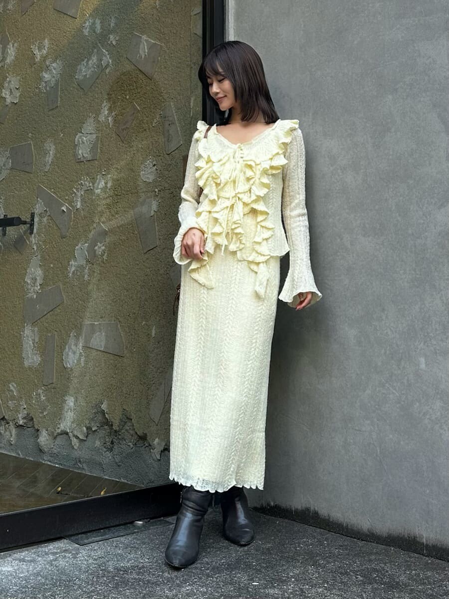 グレー系のブーツ、イエロー系のスカート、イエロー系のニット/セーターを着用したレディースの秋コーディネートの4枚目の写真