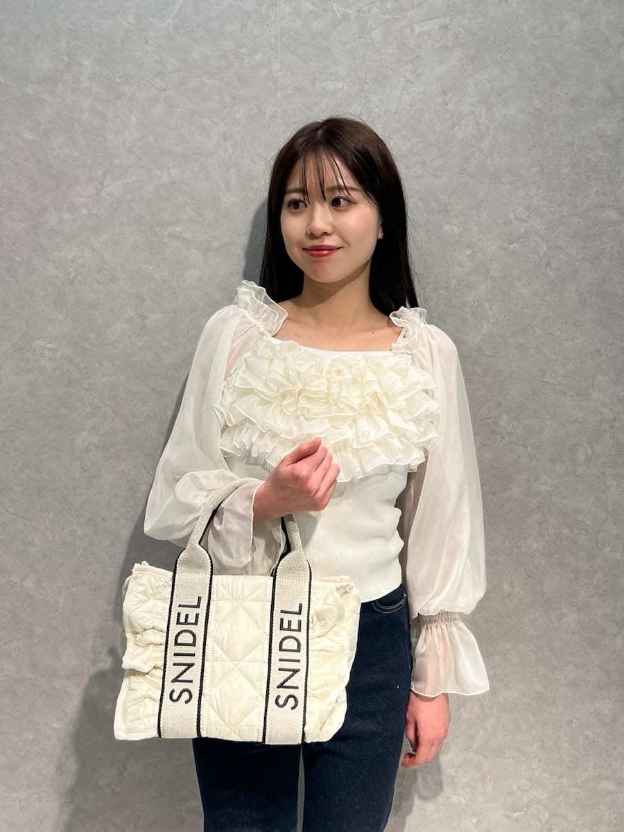 ブルー系のその他パンツ、ホワイト系のニット/セーター、ホワイト系のハンドバッグを着用したレディースの冬コーディネートの3枚目の写真