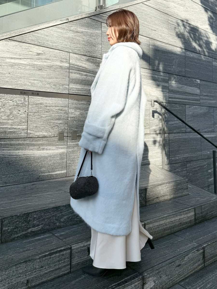 ブルー系のチェスターコート、ホワイト系のワンピースを着用したレディースの冬コーディネートの4枚目の写真