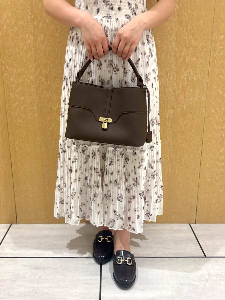 ブラウン系のハンドバッグ、ホワイト系のワンピースを着用したレディースの夏コーディネートの5枚目の写真