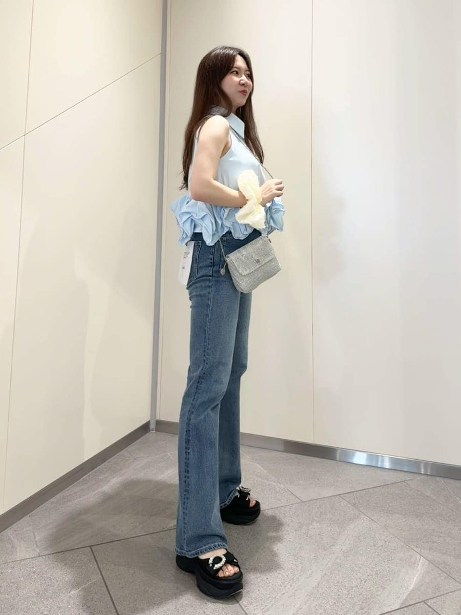 ブルー系のシャツ/ブラウス、ブラック系のサンダル、ブルー系のデニムパンツを着用したレディースの春コーディネートの3枚目の写真