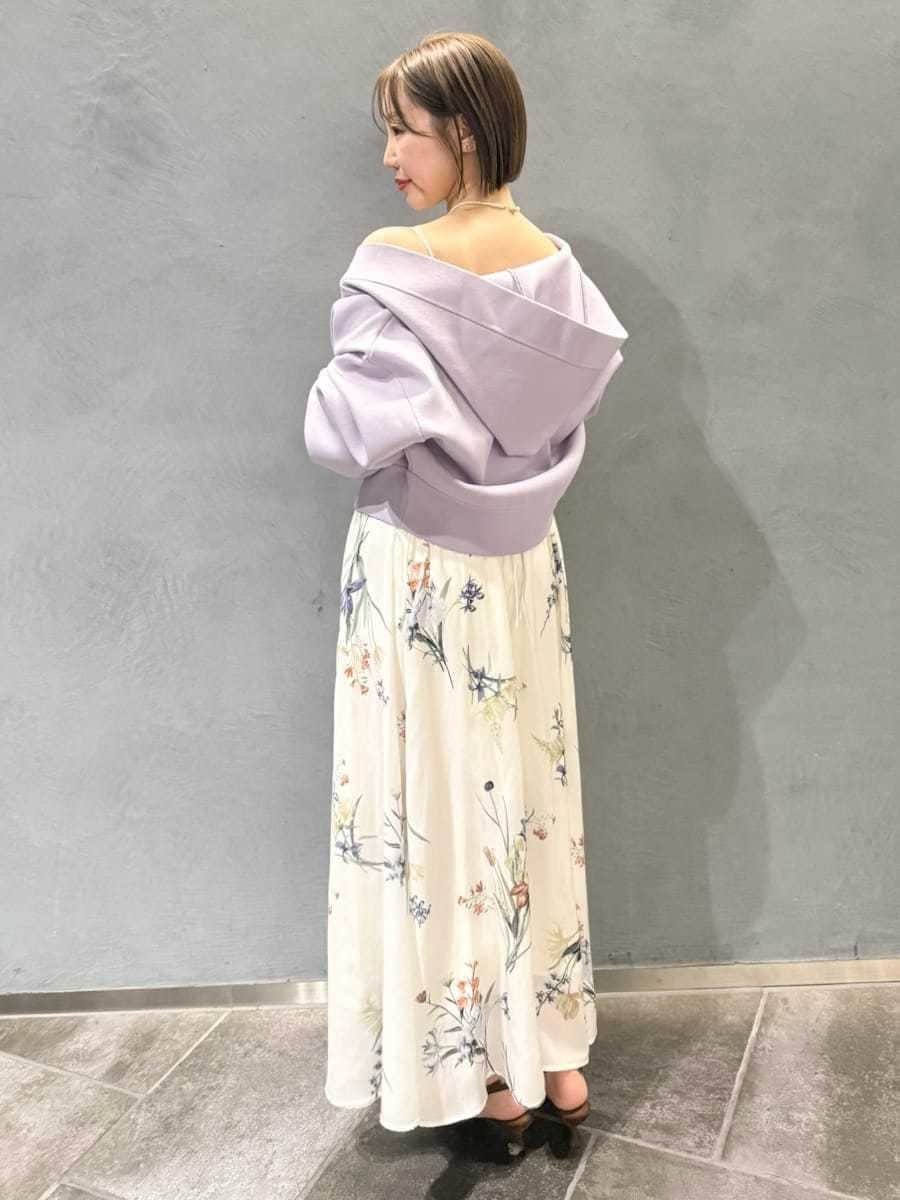 パープル系のパーカー、ホワイト系のワンピース、ブラウン系のパンプスを着用したレディースの冬コーディネートの2枚目の写真