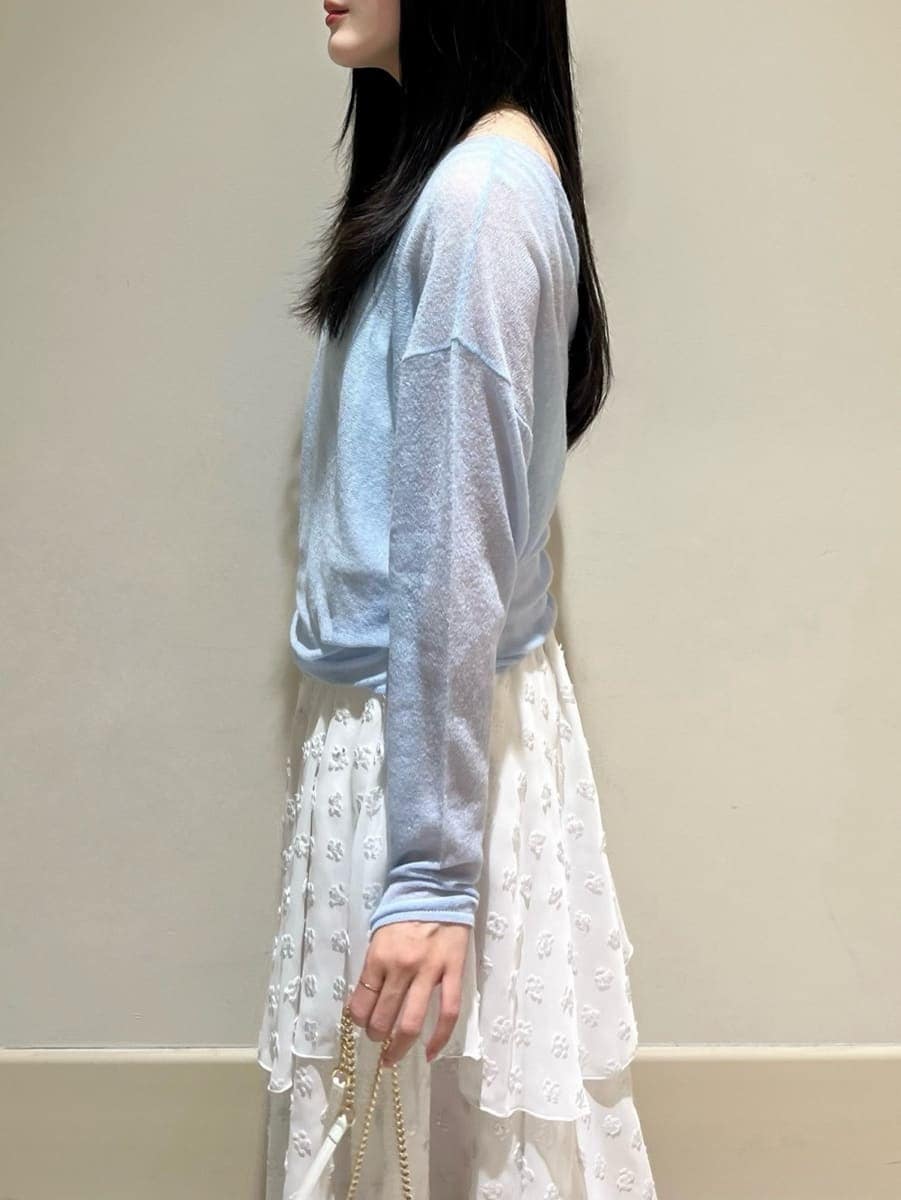 シルバー系のスカート、ブルー系のニット/セーター、ホワイト系のショルダーバッグを着用したレディースの冬コーディネートの4枚目の写真