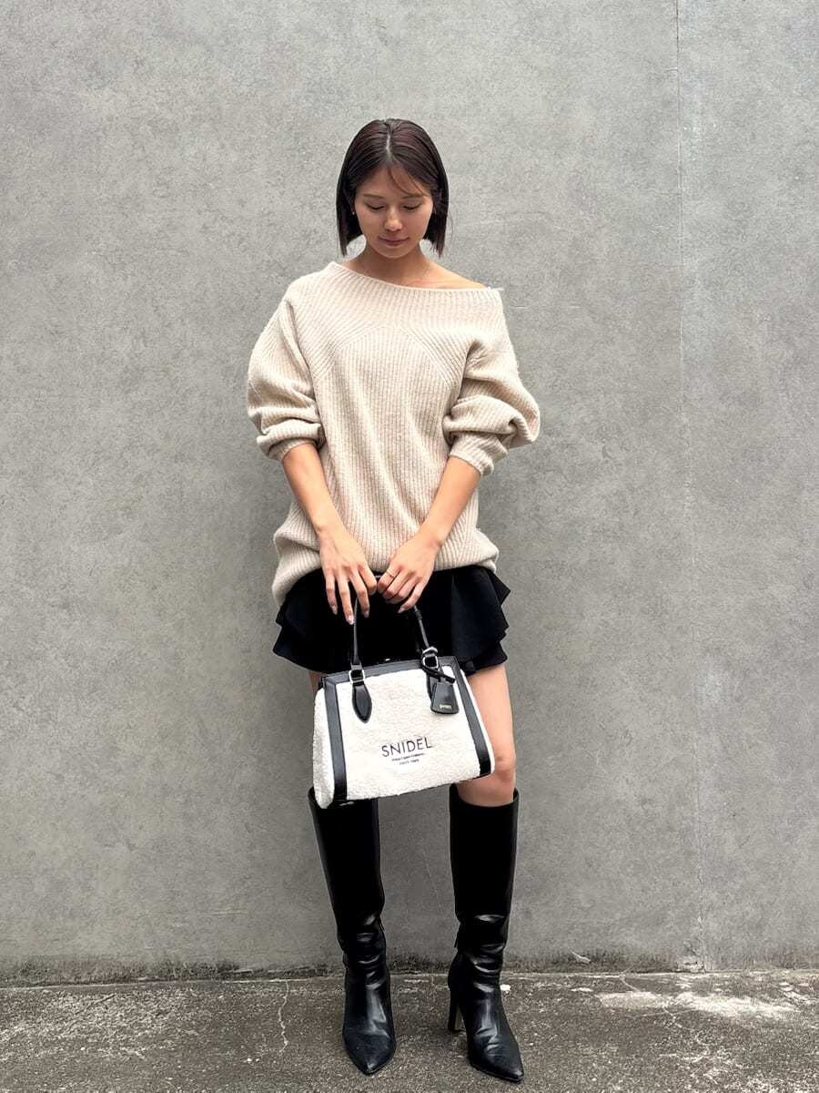 ブラック系のブーツ、ブラック系のハンドバッグ、ブラック系のその他パンツを着用したレディースの秋コーディネートの2枚目の写真