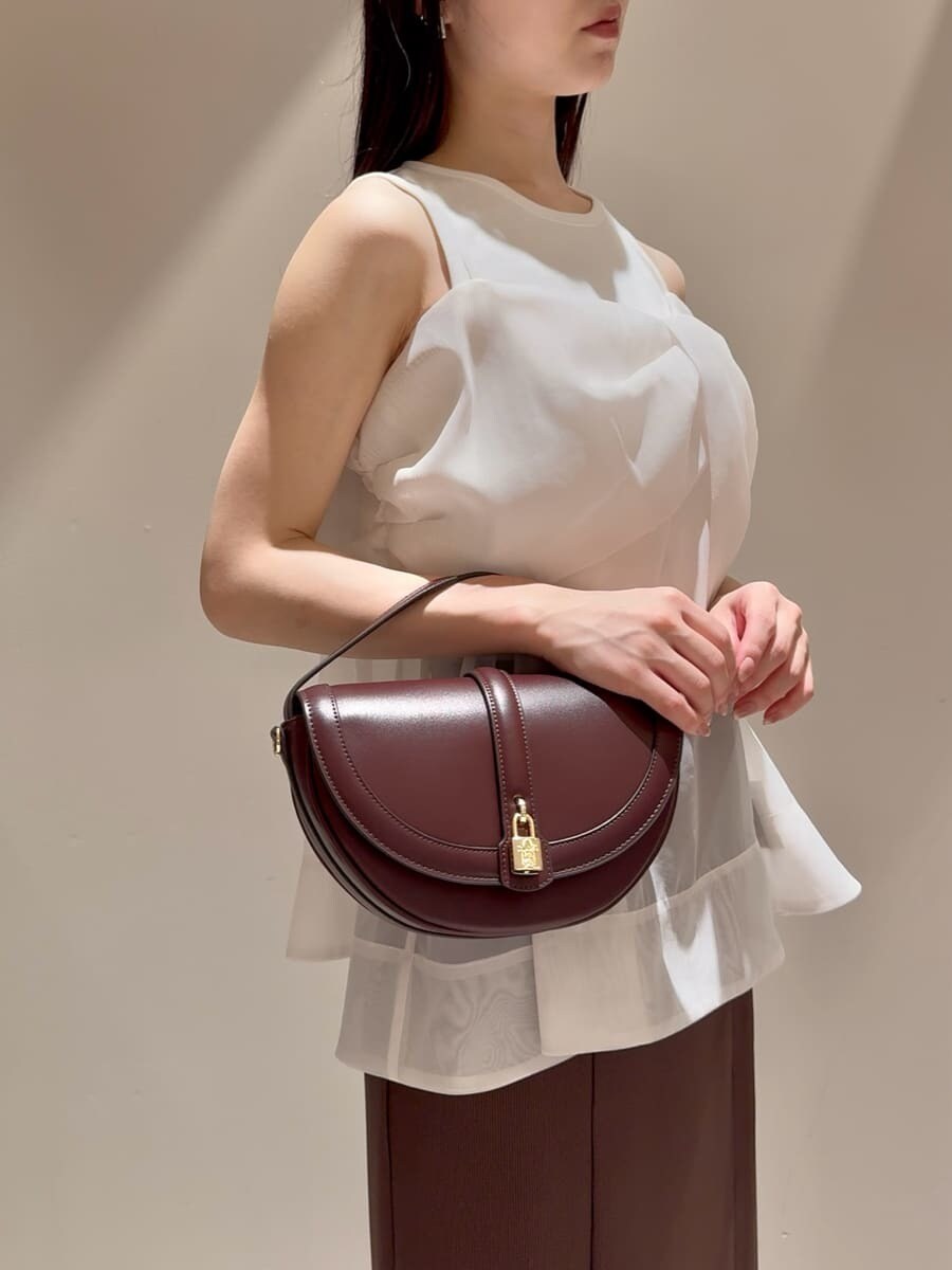 ホワイト系のTシャツ/カットソー、ブラウン系のスカート、ブラウン系のハンドバッグを着用したレディースの夏コーディネートの5枚目の写真