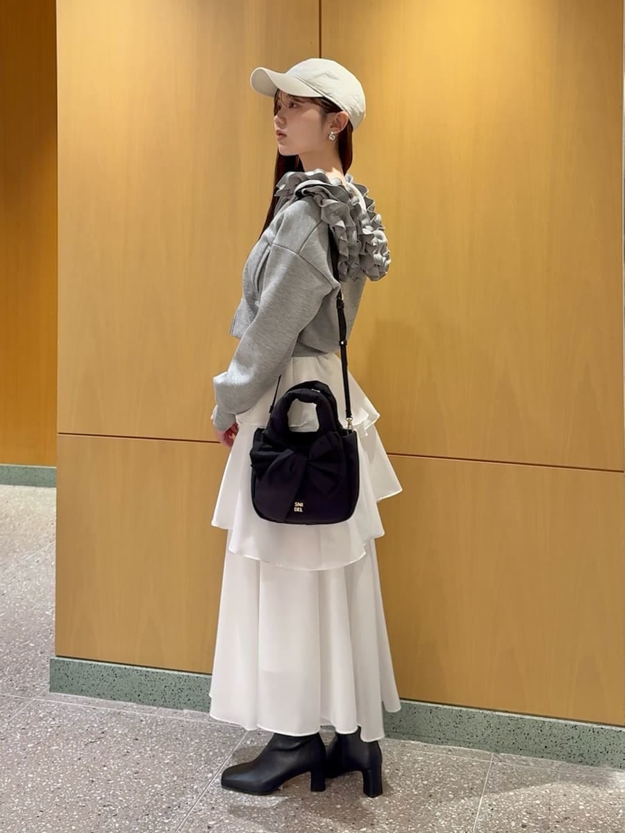 イエロー系のワンピース、グレー系のパーカー、シルバー系のピアス（両耳用）を着用したレディースの冬コーディネートの2枚目の写真