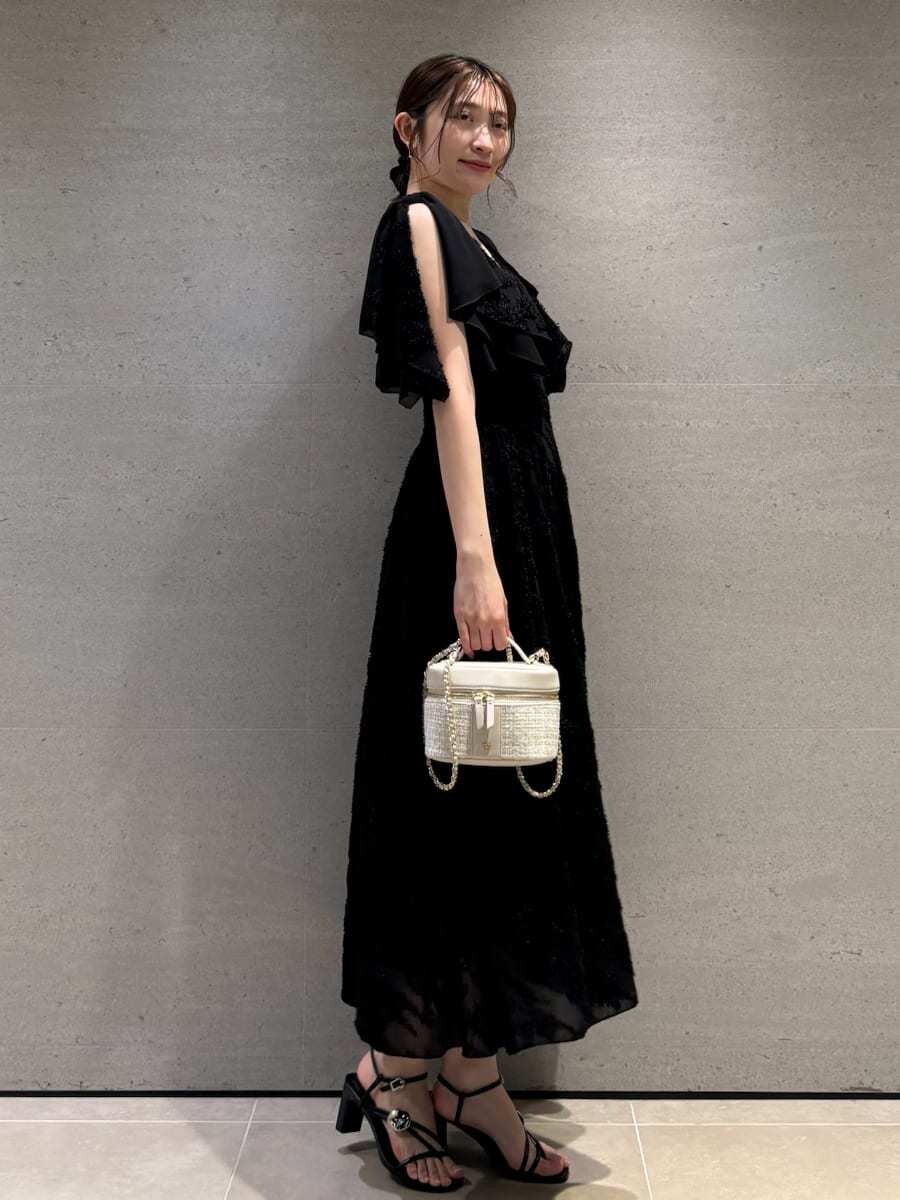 ブラック系のワンピースを着用したレディースの春コーディネートの3枚目の写真