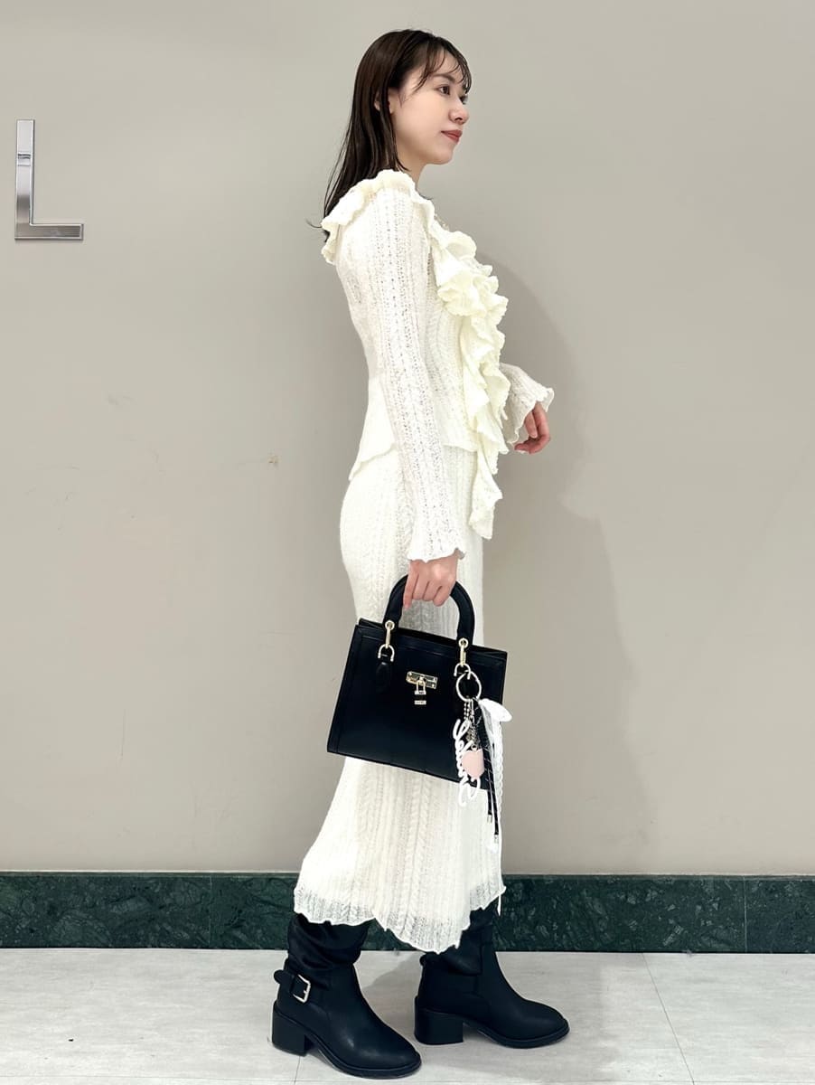ホワイト系のスカート、ホワイト系のニット/セーター、ブラック系のハンドバッグを着用したレディースの秋コーディネートの4枚目の写真