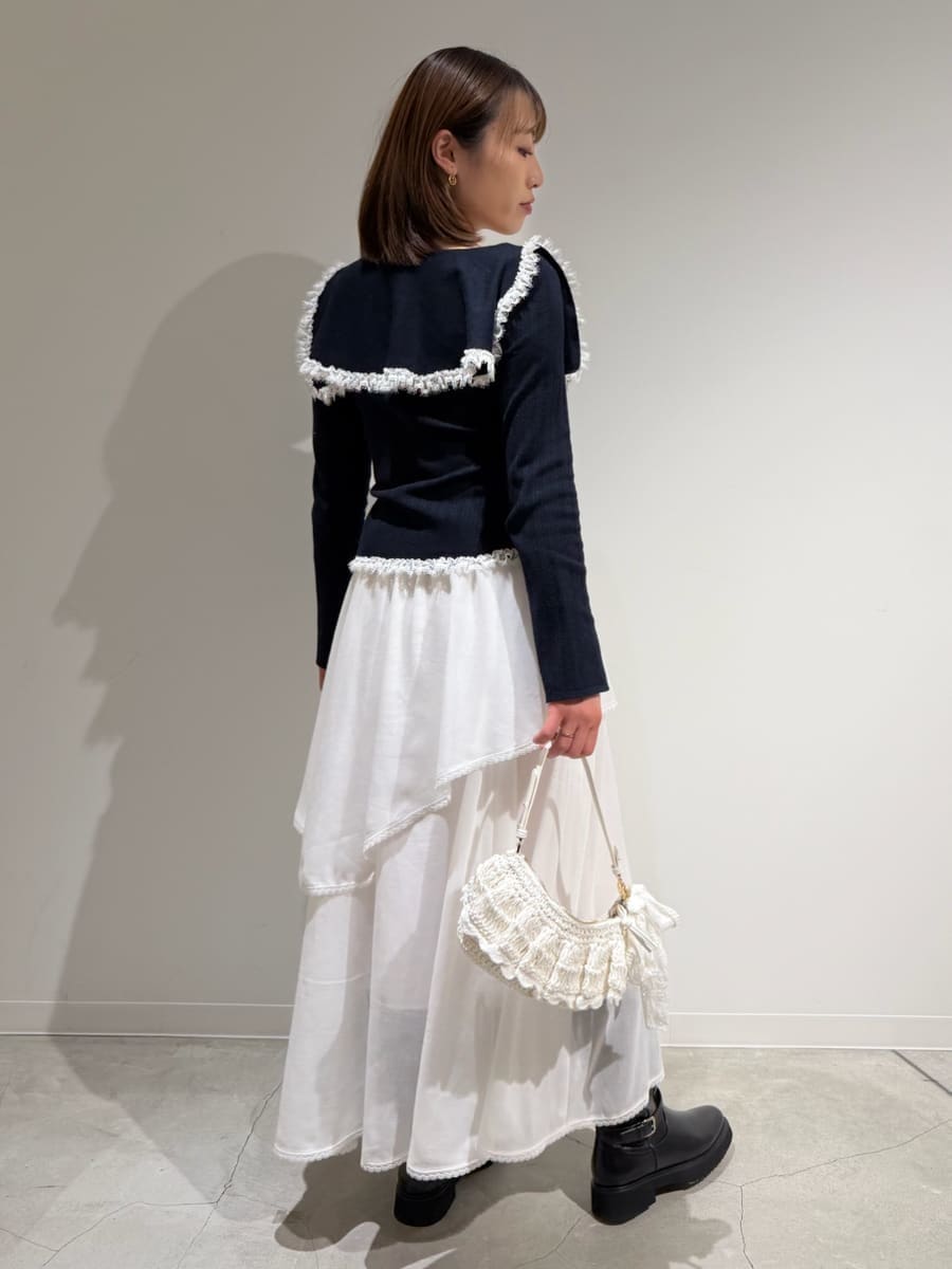 ブラック系のブーツ、ホワイト系のスカート、ブルー系のニット/セーターを着用したレディースの冬コーディネートの5枚目の写真