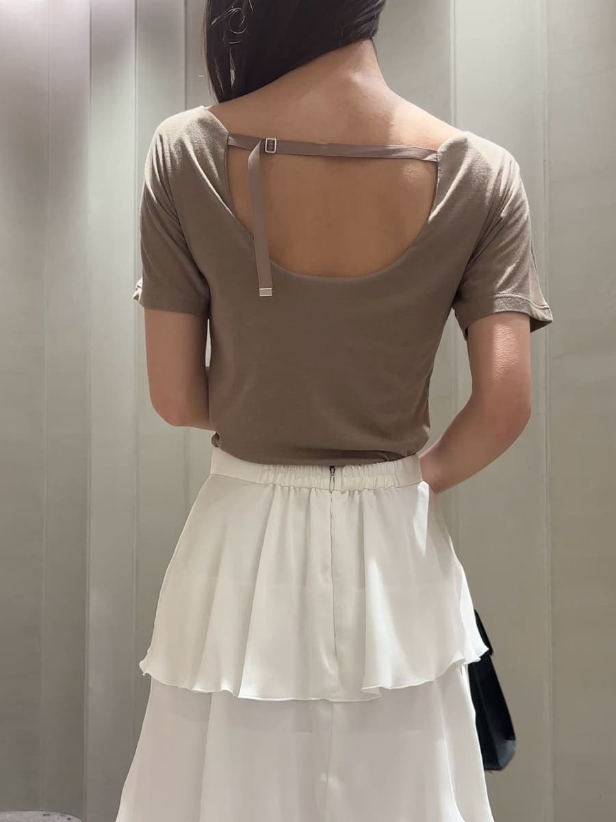 ブラック系のハンドバッグ、ホワイト系のスカート、ベージュ系のTシャツ/カットソーを着用したレディースの夏コーディネートの5枚目の写真