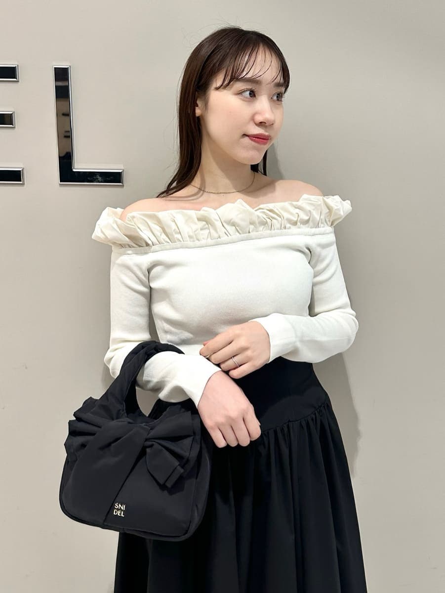 ブラック系のスカート、ホワイト系のニット/セーターを着用したレディースの冬コーディネートの2枚目の写真