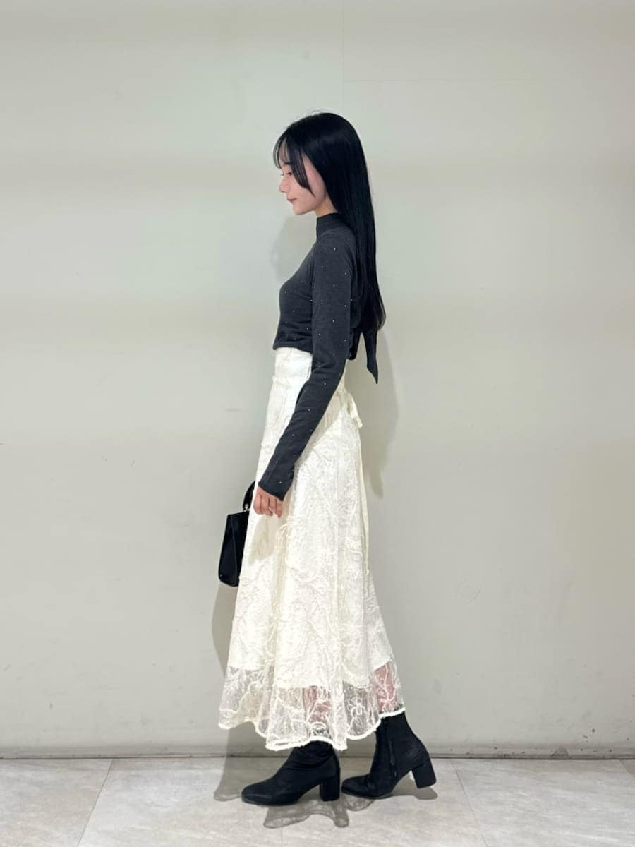 ホワイト系のスカート、グレー系のニット/セーター、ブラック系のハンドバッグを着用したレディースの秋コーディネートの3枚目の写真