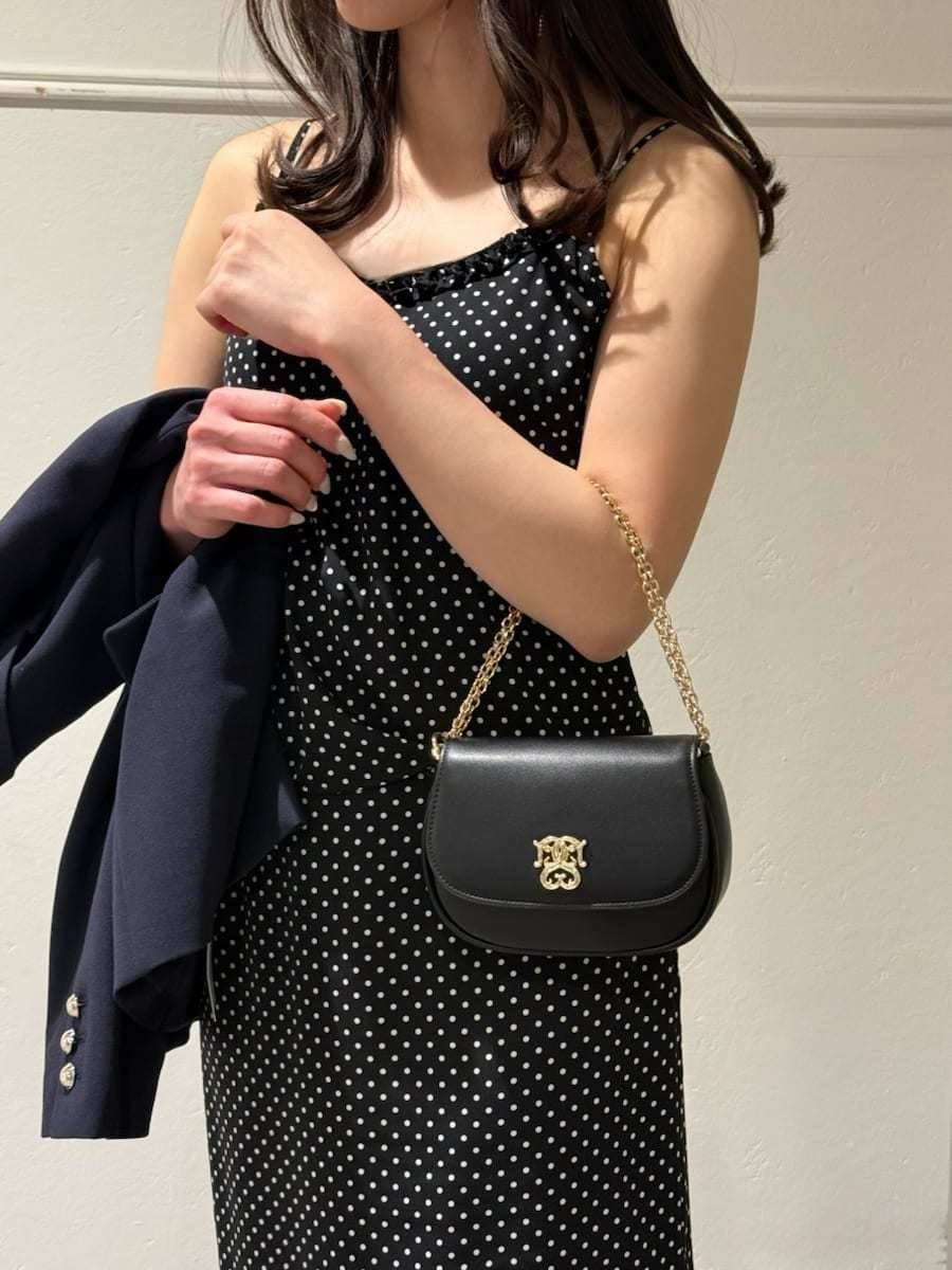 ブルー系のテーラードジャケット、ブラック系のスカート、ブラック系のキャミソールを着用したレディースの冬コーディネートの4枚目の写真