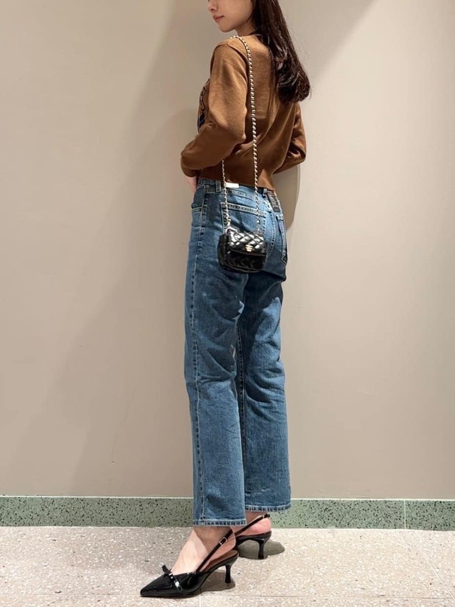 ブラウン系のカーディガン/ボレロ、ブルー系のデニムパンツ、ブラック系のショルダーバッグを着用したレディースの秋コーディネートの2枚目の写真