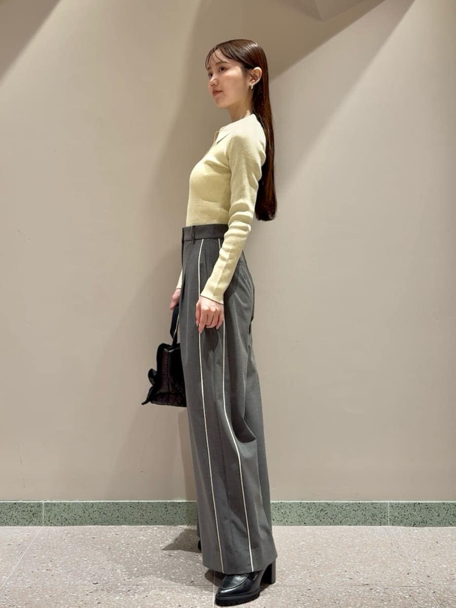 イエロー系のニット/セーター、グレー系のその他パンツ、ブラック系のローファーを着用したレディースの秋コーディネートの2枚目の写真