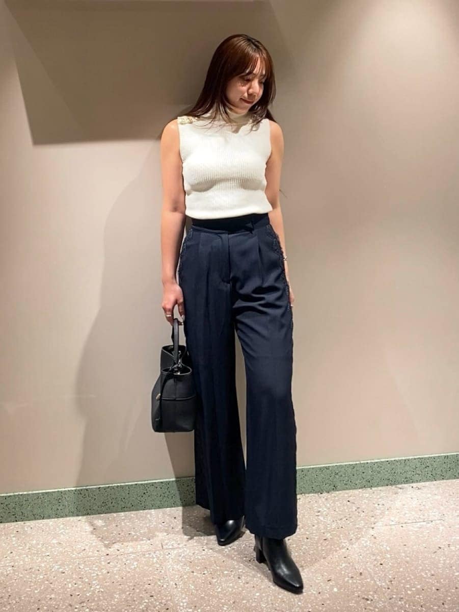 ブラック系のハンドバッグ、ブルー系のその他パンツ、ホワイト系のニット/セーターを着用したレディースの夏コーディネートの2枚目の写真