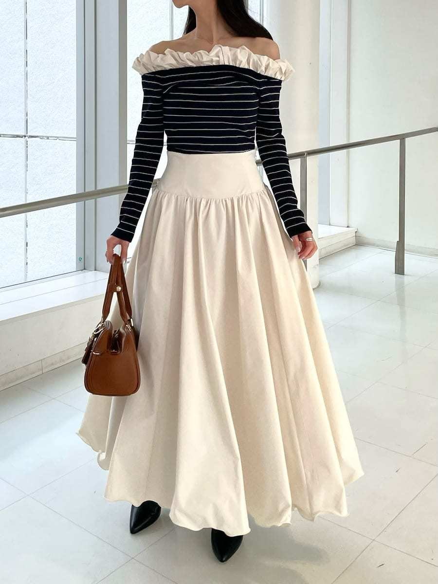 ブラック系のブーツ、ホワイト系のスカート、その他のニット/セーターを着用したレディースの冬コーディネートの3枚目の写真