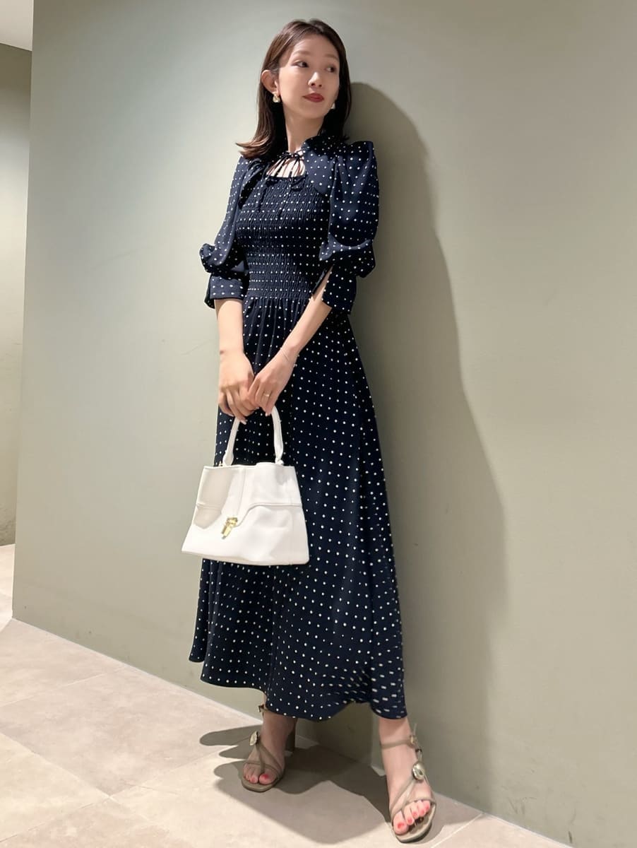 ホワイト系のハンドバッグ、ブルー系のワンピースを着用したレディースの春コーディネートの4枚目の写真