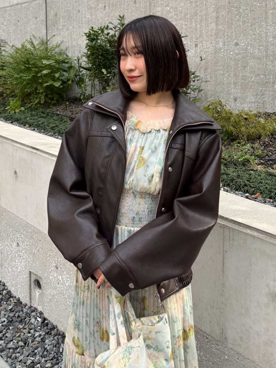 ブラウン系のブルゾン、グリーン系のワンピース、ブラウン系のパンプスを着用したレディースの冬コーディネートの3枚目の写真