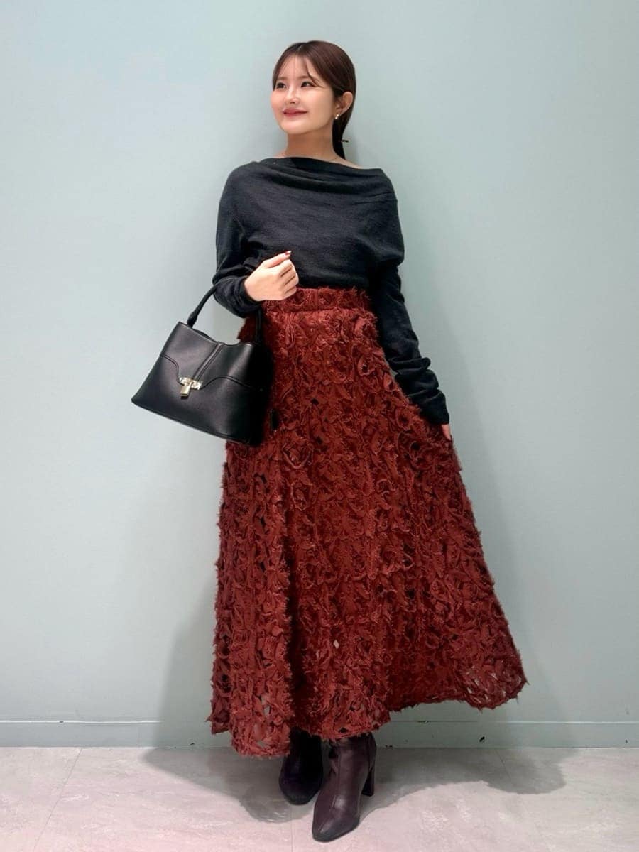 レッド系のブーツ、グレー系のチェスターコート、レッド系のスカートを着用したレディースの冬コーディネートの6枚目の写真