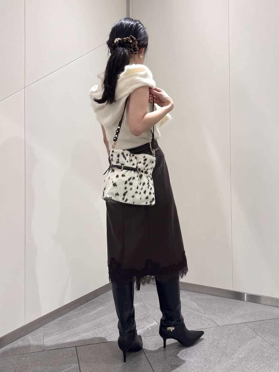 ブラウン系のスカート、ホワイト系のTシャツ/カットソー、ブラック系のブーツを着用したレディースの秋コーディネートの4枚目の写真