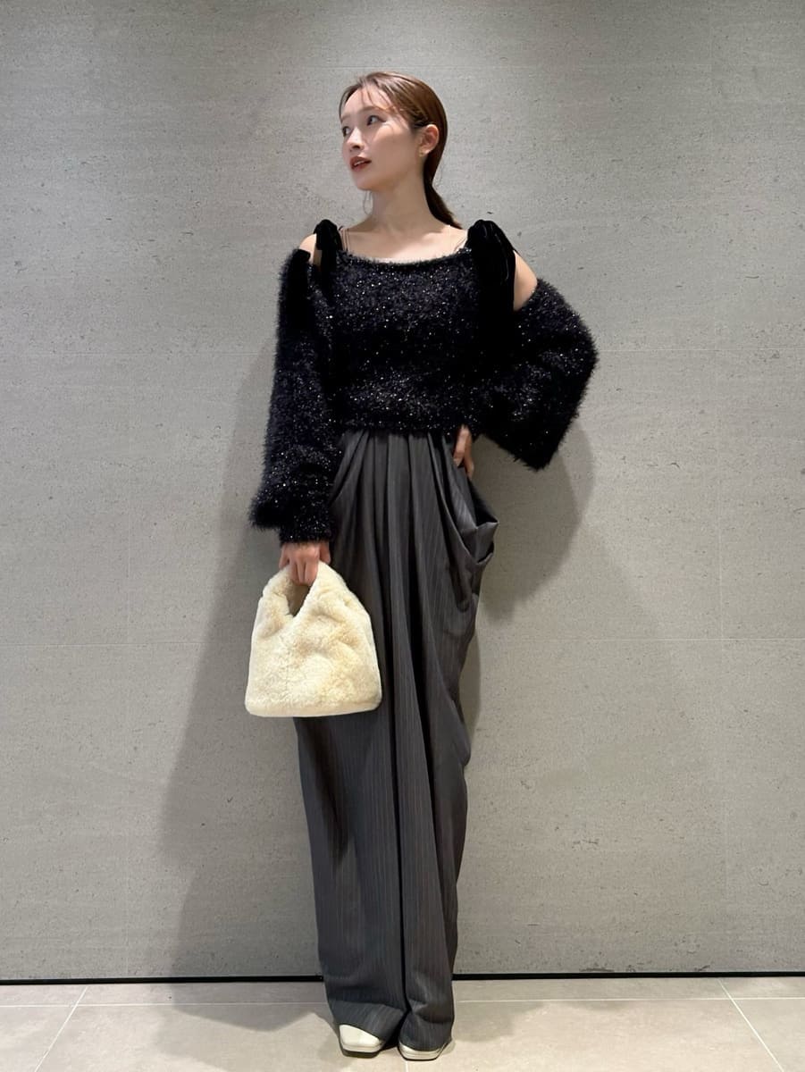 グレー系のその他パンツ、ブラック系のニット/セーター、イエロー系のハンドバッグを着用したレディースの冬コーディネートの3枚目の写真