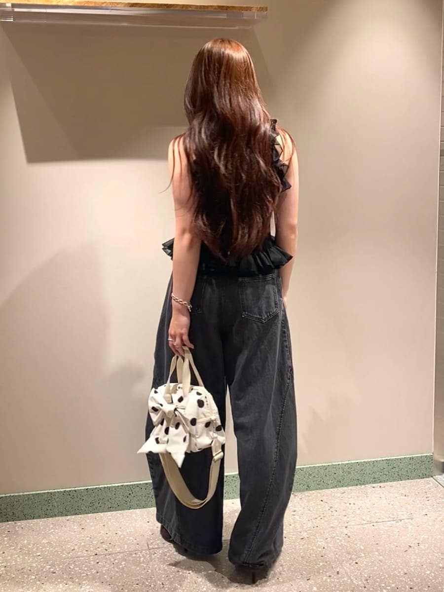 ホワイト系のショルダーバッグ、ブラック系のデニムパンツ、ブラック系のニット/セーターを着用したレディースの夏コーディネートの3枚目の写真