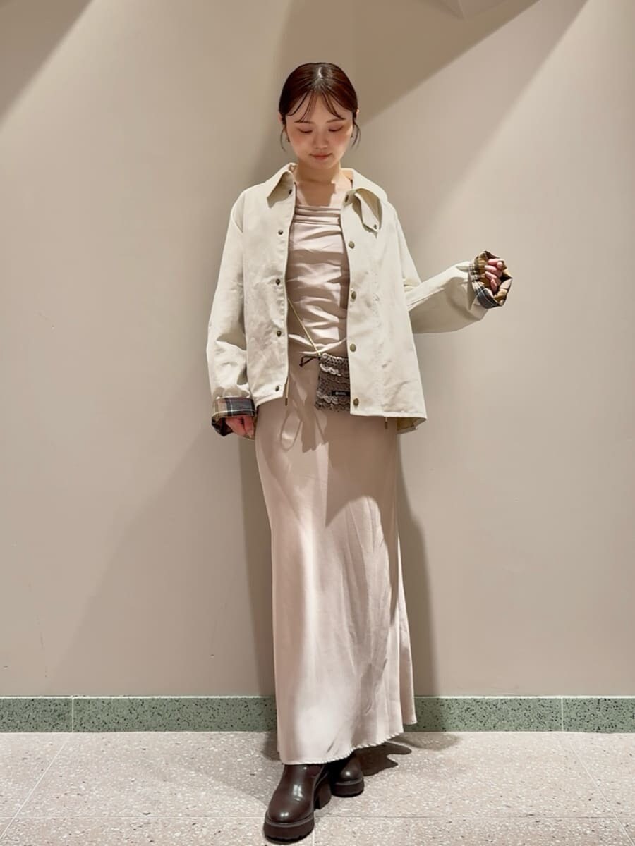 ホワイト系のブルゾン、ブラウン系のチャームを着用したレディースの秋コーディネートの2枚目の写真