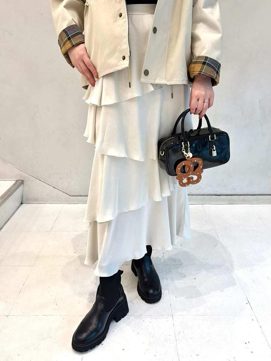 ホワイト系のブルゾン、ブラック系のニット/セーター、ホワイト系のスカートを着用したレディースの秋コーディネートの5枚目の写真