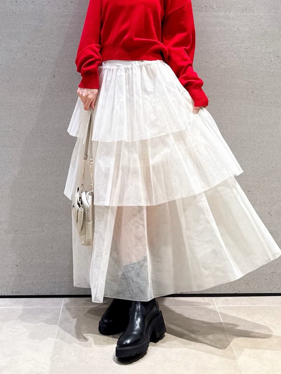 ホワイト系のスカート、レッド系のニット/セーター、ホワイト系のショルダーバッグを着用したレディースの秋コーディネートの5枚目の写真