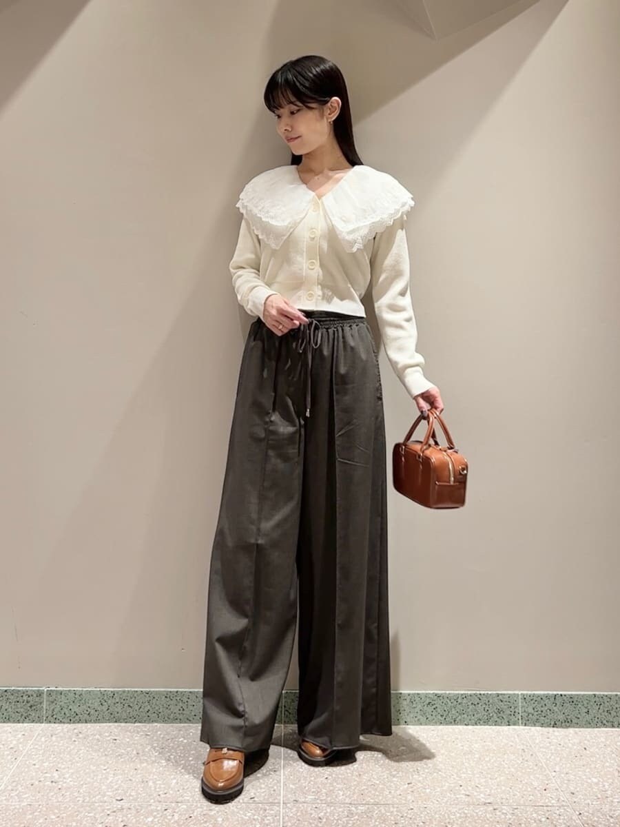 ホワイト系のニット/セーター、ブラウン系のその他パンツ、ブラウン系のボストンバッグを着用したレディースの秋コーディネートの5枚目の写真