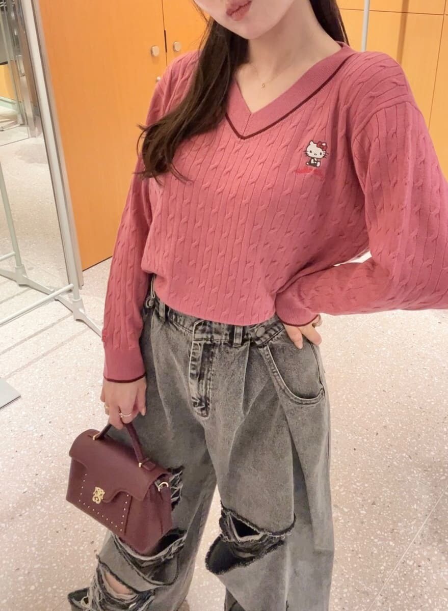 ピンク系のニット/セーター、グレー系のデニムパンツ、ブラウン系のショルダーバッグを着用したレディースの秋コーディネートの7枚目の写真